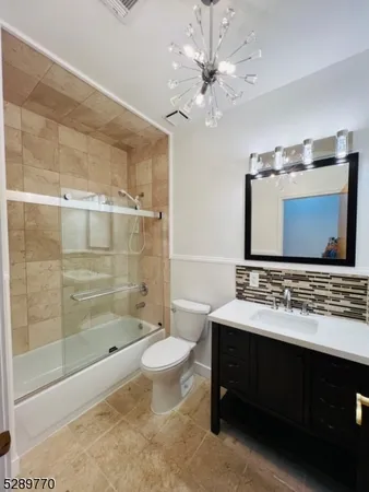 a bathroom with a double vanity sink a toilet a mirror and shower