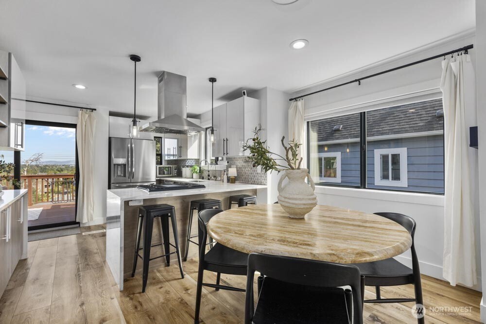 5926 34th Avenue Southwest Seattle, WA 98126 - Photo 5 of 36 a kitchen with a table chairs and wooden floor