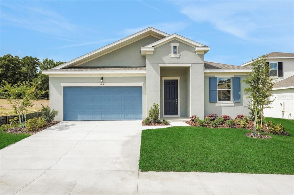 a front view of a house with a yard and garage