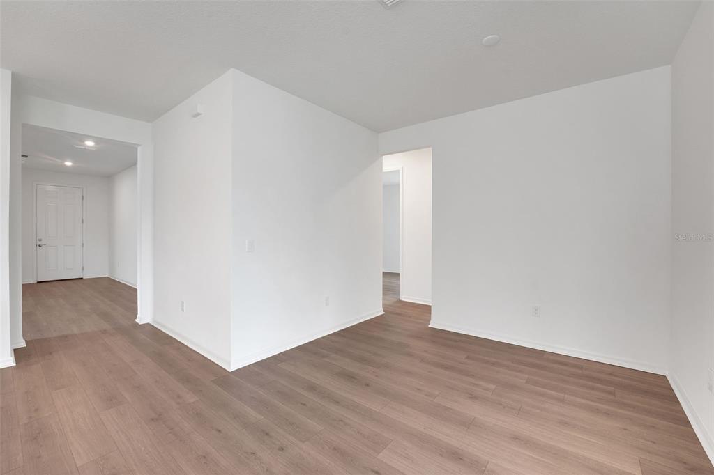 35151 Tuscan Hill Road Dade City, FL 33525 - Photo 13 of 38 a view of an empty room with wooden floor