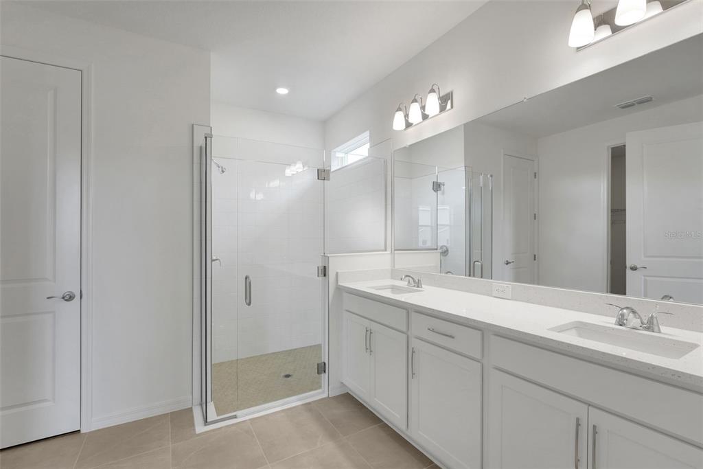 35151 Tuscan Hill Road Dade City, FL 33525 - Photo 23 of 38 a bathroom with double vanity sinks and a mirror