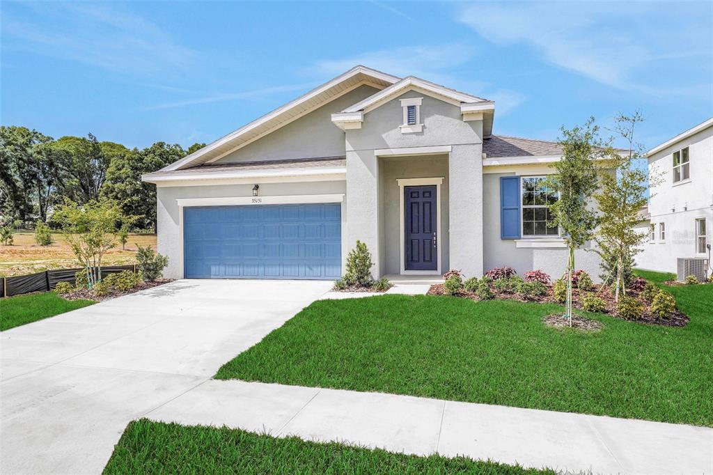 35151 Tuscan Hill Road Dade City, FL 33525 - Photo 3 of 38 a front view of a house with a garden and plants