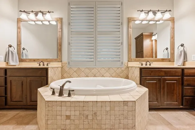 a bathroom with a tub sink and mirror