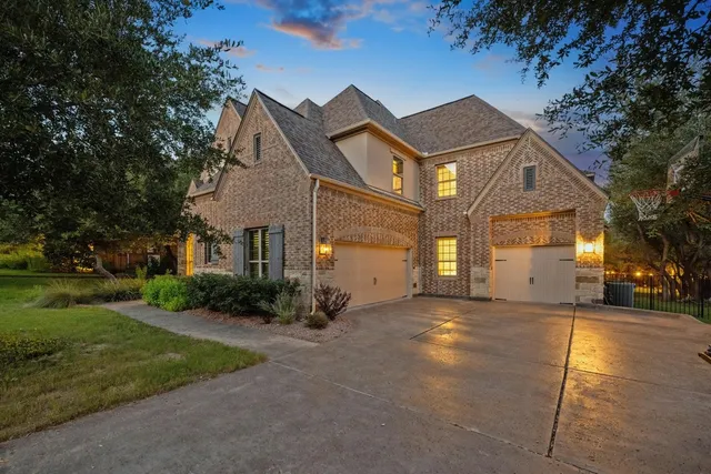 a view of a big house with a big yard and large tree