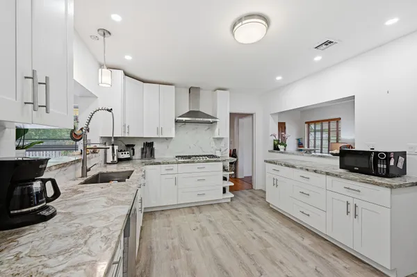 a kitchen with white cabinets and appliances