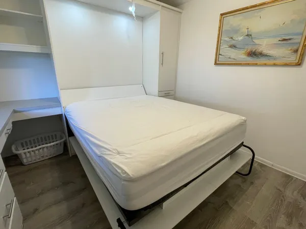 a bed sitting in a bedroom next to a wall
