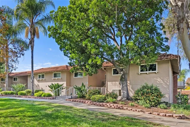 a front view of a house with a yard and potted plants