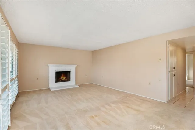 an empty room with a fireplace and window