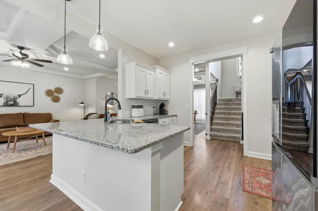 a kitchen with stainless steel appliances granite countertop a sink a stove and refrigerator