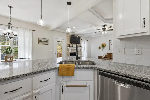 a kitchen with granite countertop stainless steel appliances a sink stove and cabinets
