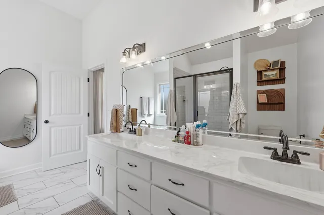 a bathroom with a double vanity sink a mirror and a shower