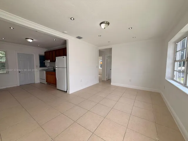 a view of empty room with a kitchen