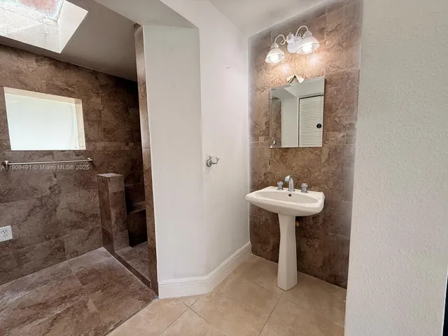a bathroom with a sink a mirror and a shower