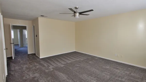 a view of a livingroom with a ceiling fan and wooden floor