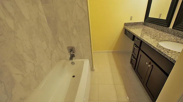 a bathroom with a granite countertop sink and a mirror