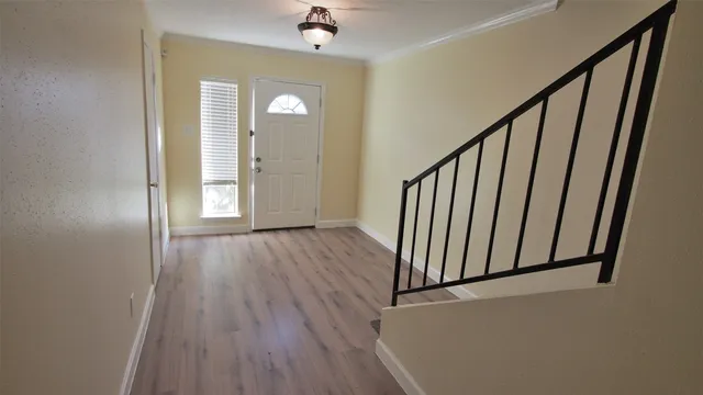 a view of a hallway with wooden floor and staircase
