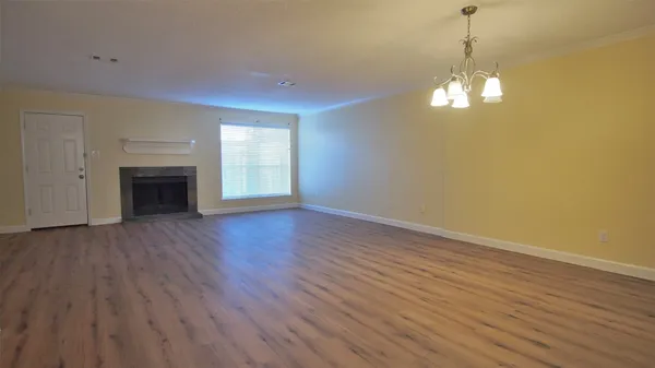 a view of empty room with wooden floor and fireplace