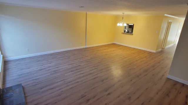 a view of a room with wooden floor
