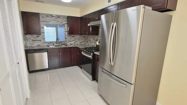 a kitchen with stainless steel appliances granite countertop a refrigerator and a sink