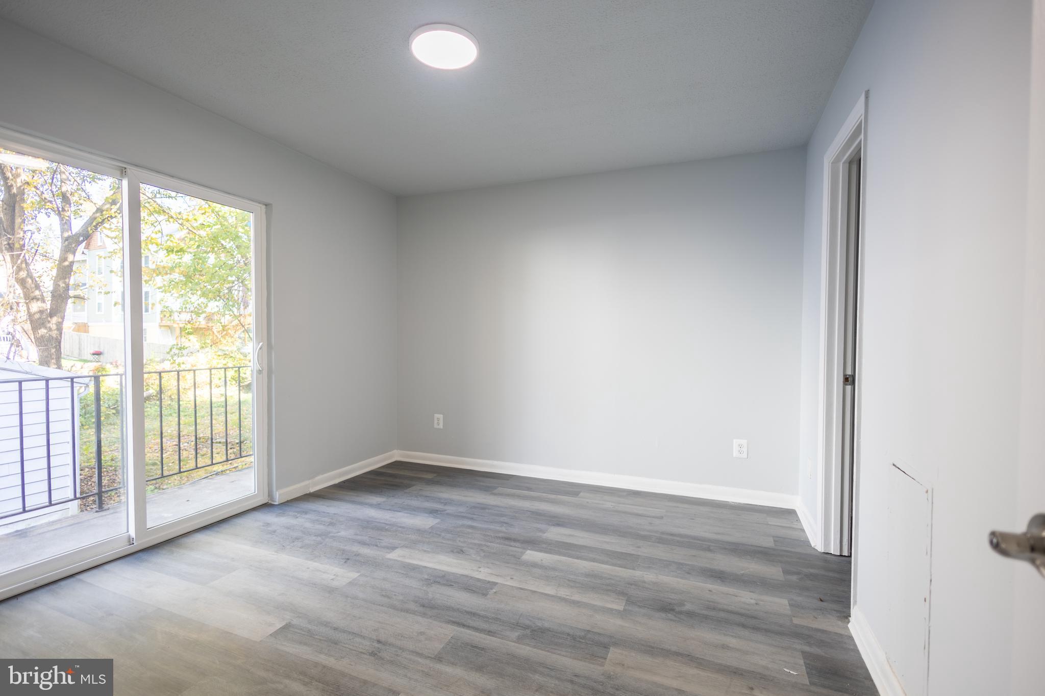 1300-1302 Morris Road Southeast, Unit A6 Washington, DC 20020 - Photo 5 of 13 a view of an empty room with wooden floor and a window