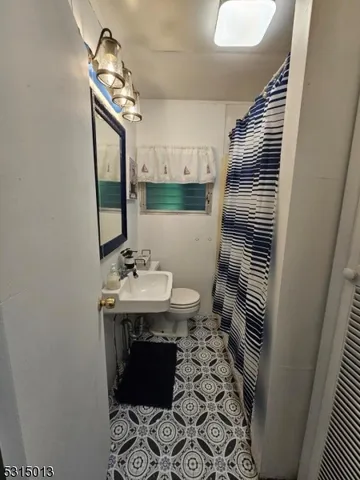 a bathroom with a sink a toilet and mirror