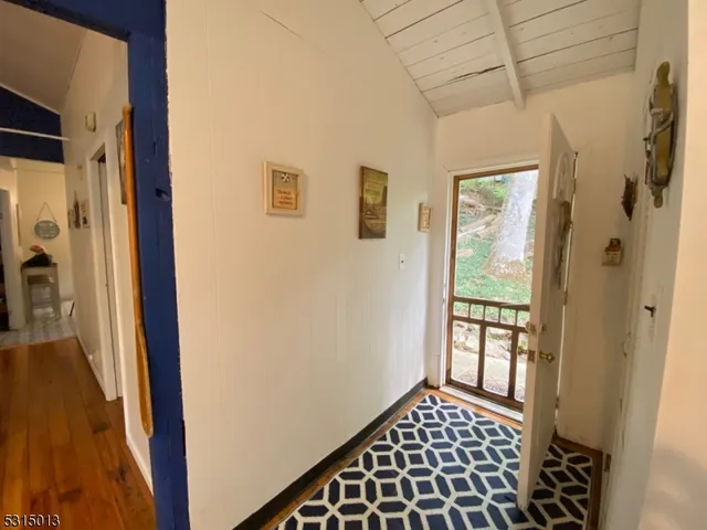 a view of a hallway with wooden floor and a livingroom