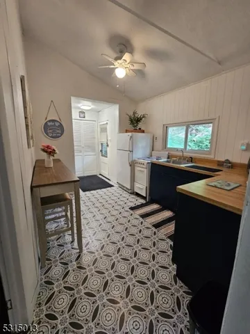 a kitchen with a sink a stove a microwave cabinets and a dining table