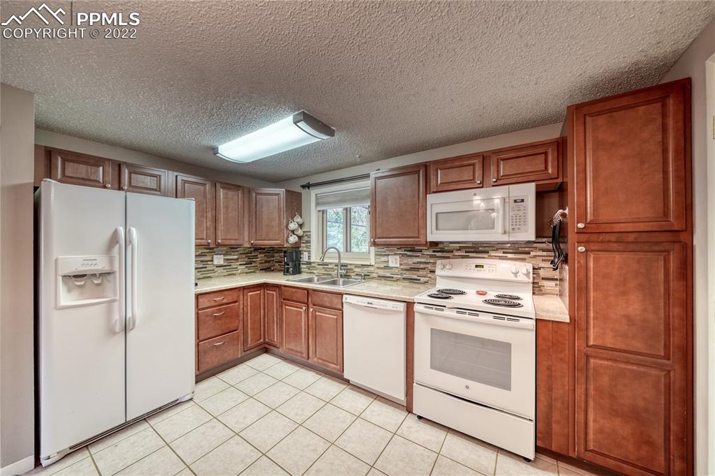 7035 Chippewa Road Colorado Springs, CO 80915 - Photo 18 of 22 a kitchen with stainless steel appliances granite countertop a refrigerator sink and cabinets
