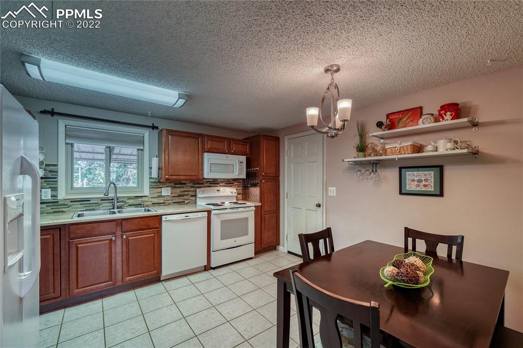 7035 Chippewa Road Colorado Springs, CO 80915 - Photo 10 of 22 a open kitchen with stainless steel appliances granite countertop a sink dishwasher and cabinets with wooden floor