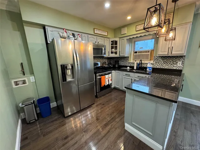a kitchen with stainless steel appliances granite countertop a refrigerator a stove and a sink