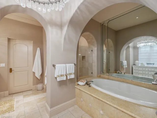a spacious bathroom with a tub and mirror