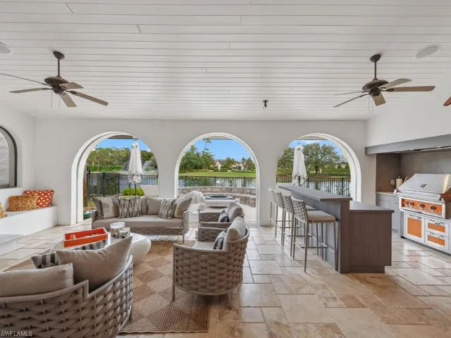 a living room with couches a fireplace and a dining table with garden view