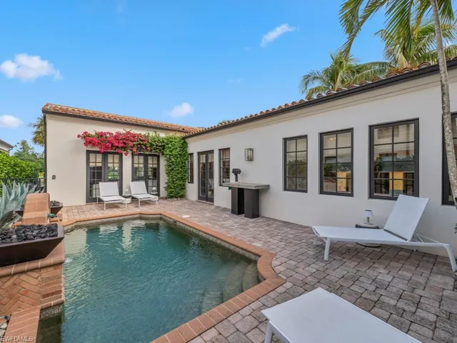a view of a house with swimming pool and sitting area