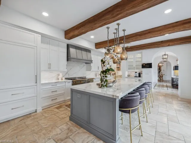 a kitchen with stainless steel appliances kitchen island granite countertop a table and chairs in it