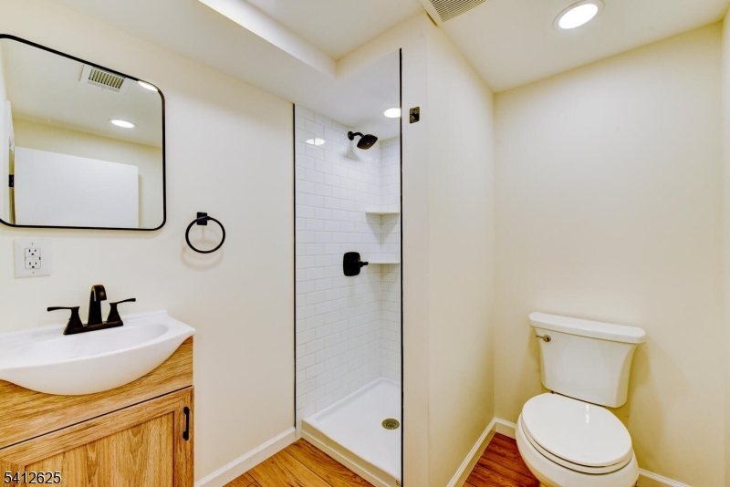 39 Old Road Ringwood, NJ 07456 - Photo 33 of 43 a bathroom with a toilet a sink a mirror a vanity and shower