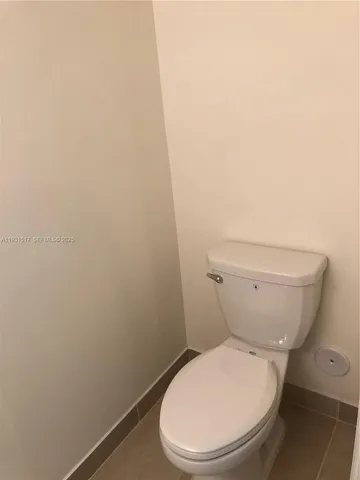a white toilet sitting next to a white wall