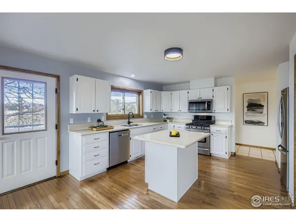 a kitchen with cabinets and wooden floor