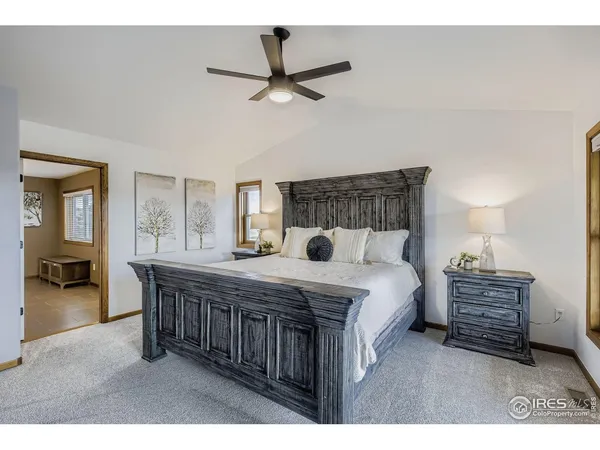 a bedroom with a bed a chandelier and dresser