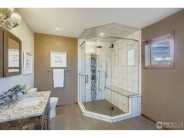 a bathroom with a granite countertop sink a shower and a mirror