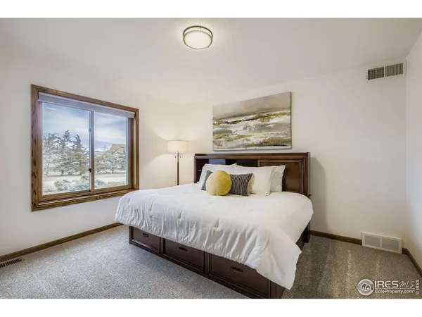 a bedroom with a large bed and a window