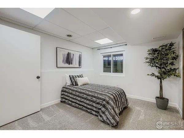 a bedroom with a bed lamp and a potted plant