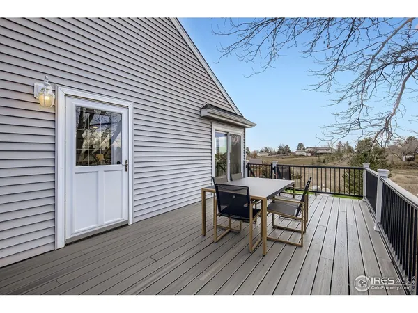 a view of a roof deck with table and chairs a barbeque with wooden floor and fence