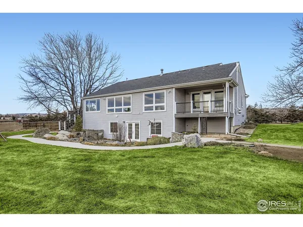 a view of a house with a big yard and large trees