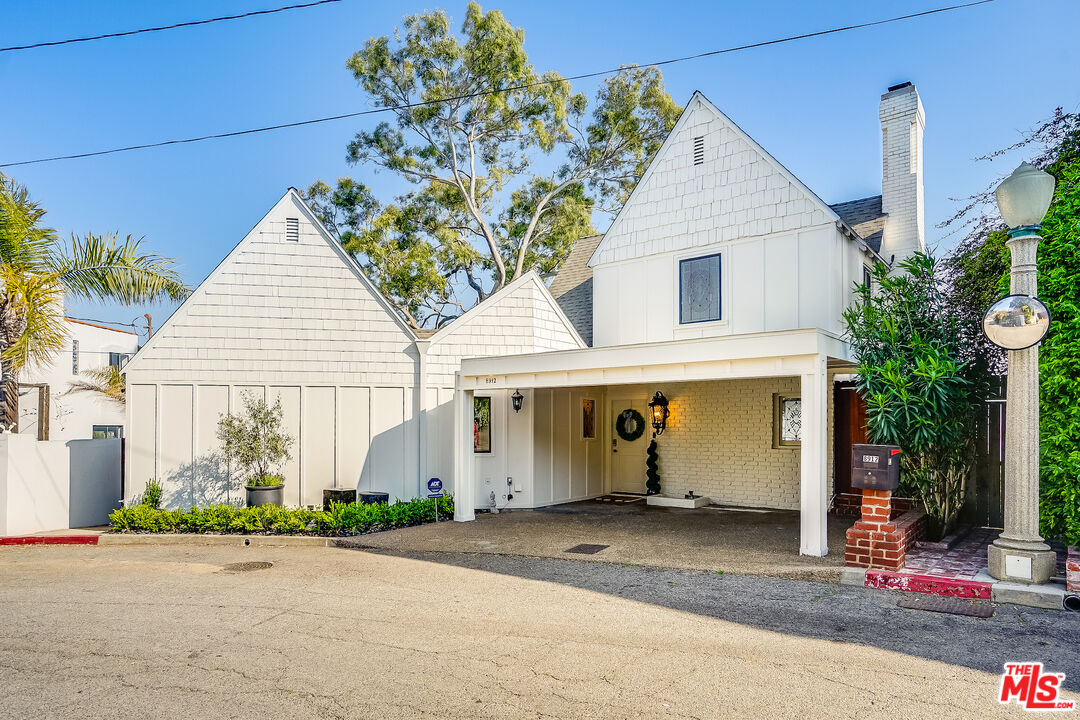 8912 Appian Way Los Angeles, CA 90046 - Photo 1 of 55 a view of a white house with potted plants and a large tree