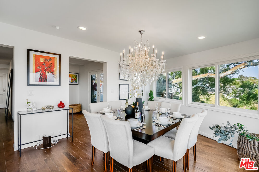 8912 Appian Way Los Angeles, CA 90046 - Photo 13 of 55 a view of a dining room with furniture a chandelier and wooden floor