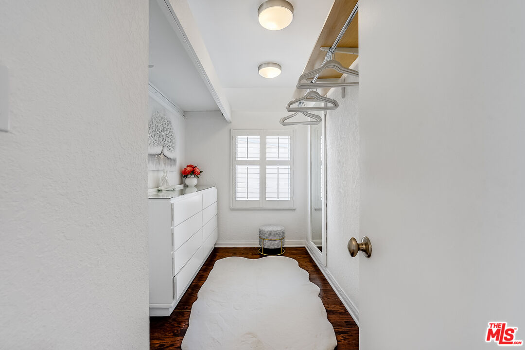 8912 Appian Way Los Angeles, CA 90046 - Photo 35 of 55 a hallway with a white cabinets and wooden floor