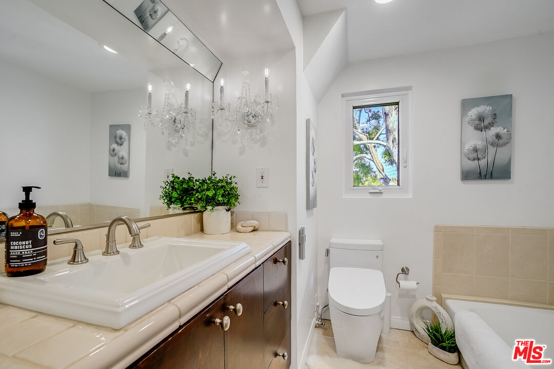 8912 Appian Way Los Angeles, CA 90046 - Photo 37 of 55 a bathroom with a toilet a sink and mirror
