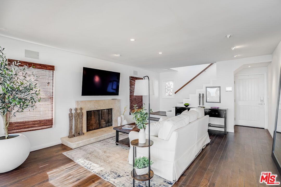 8912 Appian Way Los Angeles, CA 90046 - Photo 6 of 55 a living room with furniture a flat screen tv and a fireplace