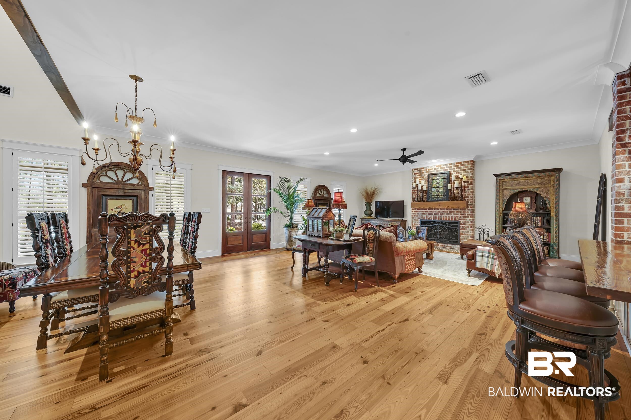 12161 Jessamine Street Magnolia Springs, AL 36555 - Photo 9 of 70 Dining space with a brick fireplace, light wood-type flooring, a ceiling fan, suspended lighting, and ornamental molding
