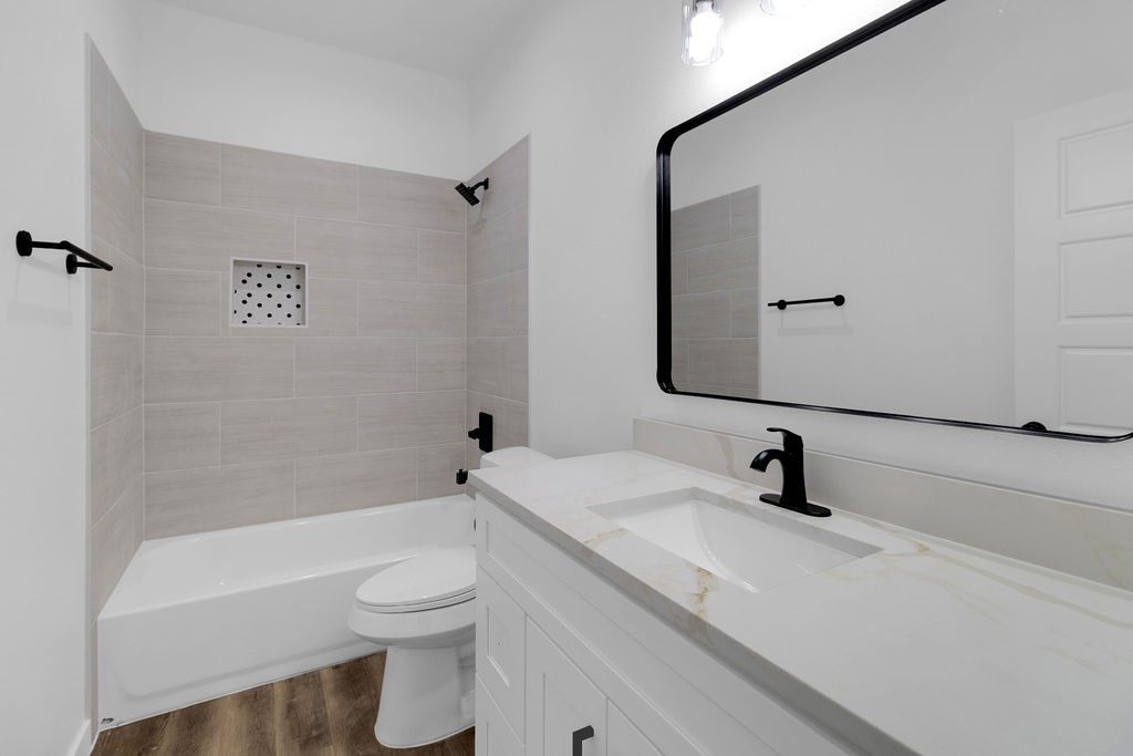 104 Runnels Street Willis, TX 77378 - Photo 14 of 27 a bathroom with a sink a toilet and a bathtub
